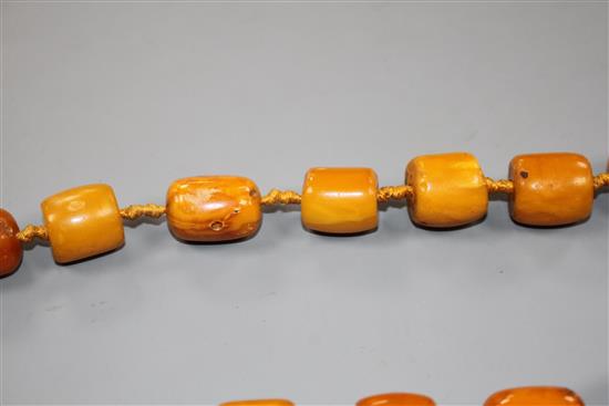 A single strand barrel shaped amber bead necklace, 86cm.